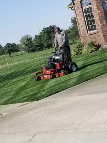 professional lawn care team mowing lawn